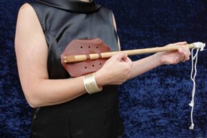 A close-up of a woman's arm holding a lute.
